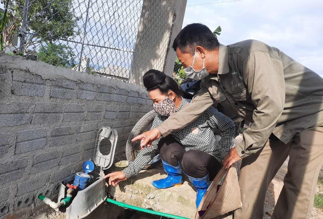 Công nhân nhà máy nước thành phố Điện Biên Phủ hướng dẫn người dân xã Thanh Hưng, huyện Điện Biên theo dõi, quản lý đồng hồ nước.