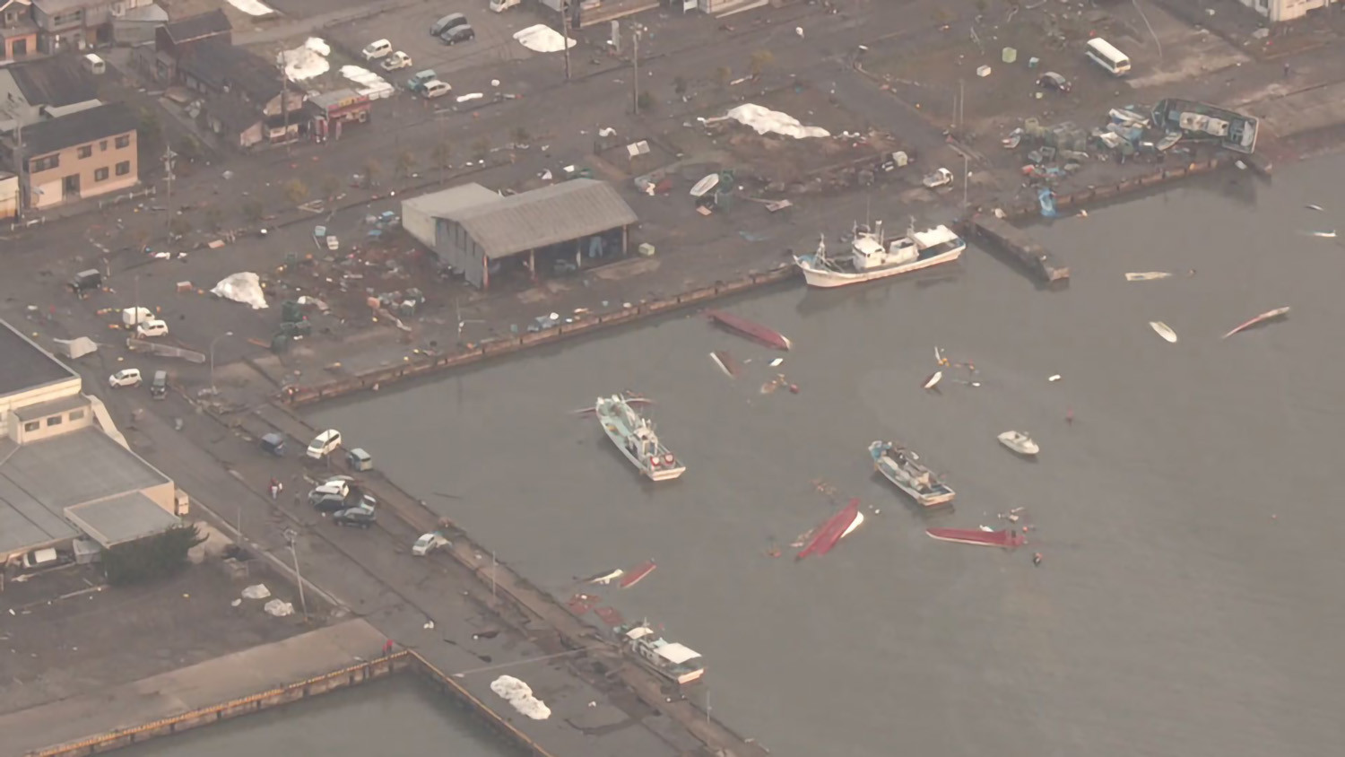 Tại cảng của thành phố Suzu, có thể thấy một số thuyền bị lật úp và nhiều thuyền đâm vào bến. Ảnh: NHK