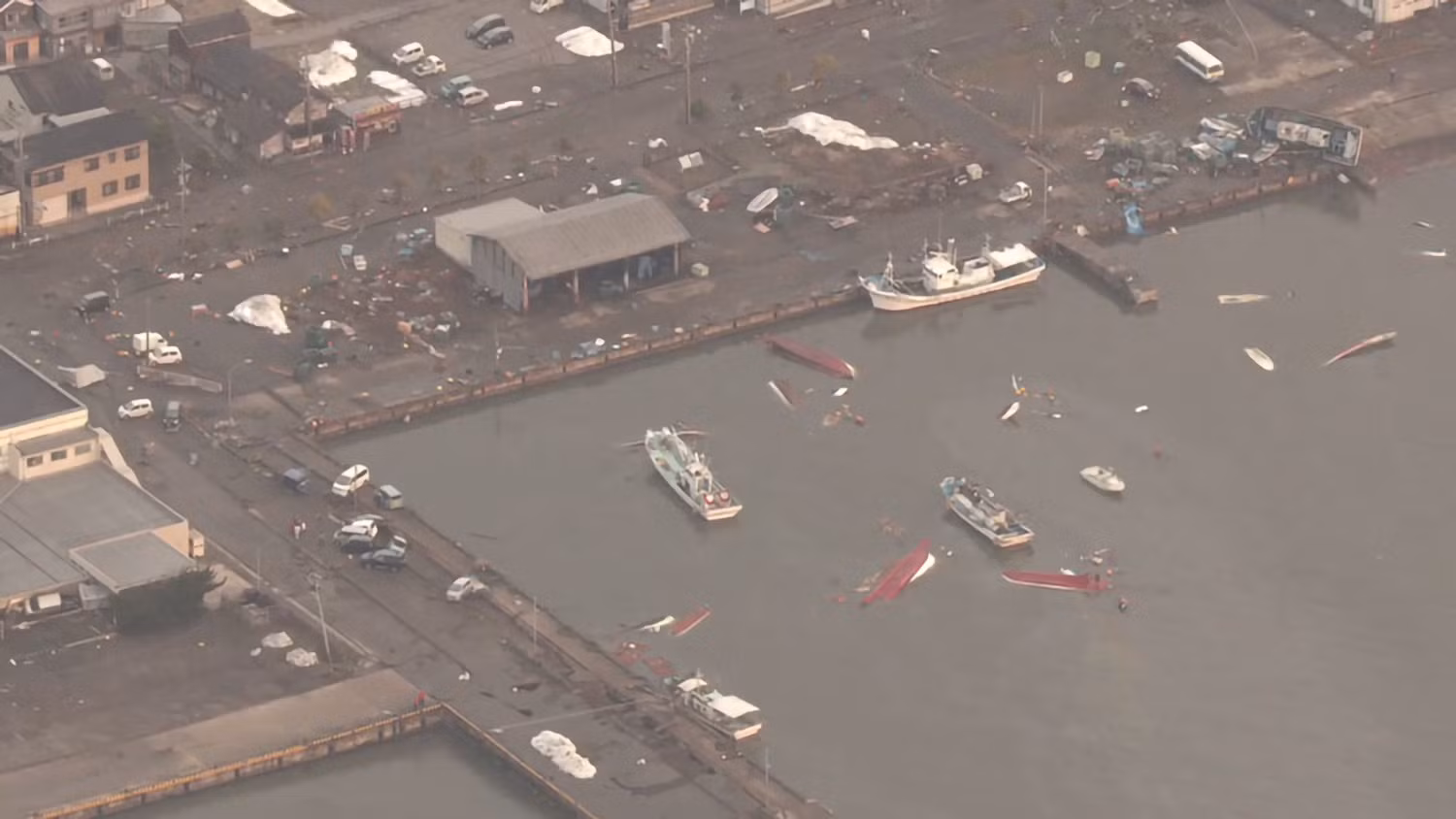 Tại cảng của thành phố Suzu, có thể thấy một số thuyền bị lật úp và nhiều thuyền đâm vào bến. Ảnh: NHK