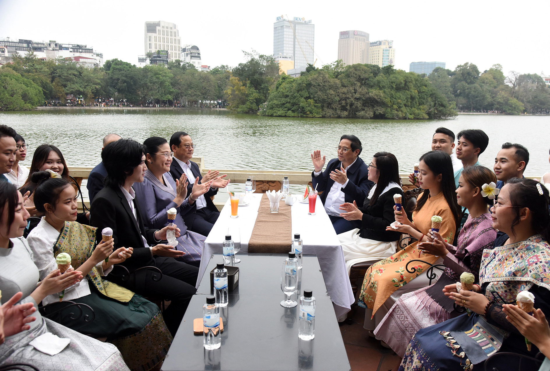 Thủ tướng Phạm Minh Chính và Phu nhân cùng Thủ tướng Lào Sonexay Siphandone và Phu nhân trò chuyện, uống cà phê bên hồ Gươm vỗ tay theo nhịp điệu khi sinh viên hai nước hát bài về quan hệ đặc biệt Việt Nam-Lào.
