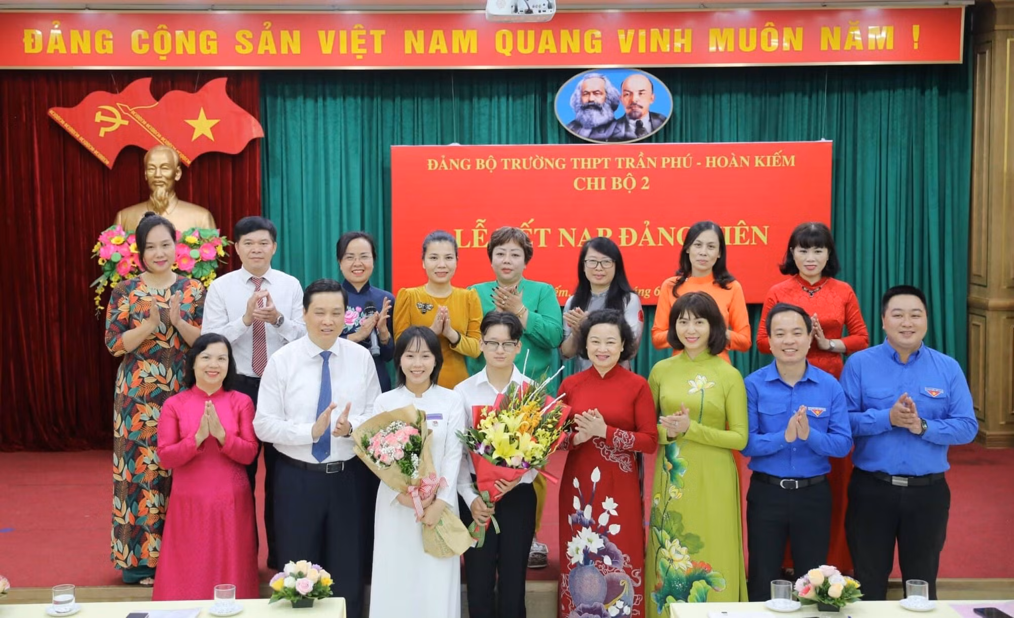 Các đại biểu Thành ủy Hà Nội, Quận uỷ Hoàn Kiếm chúc mừng hai đảng viên trẻ là học sinh lớp 12 của Trường Trần Phú-Hoàn Kiếm. (Ảnh: Thế Đại.)