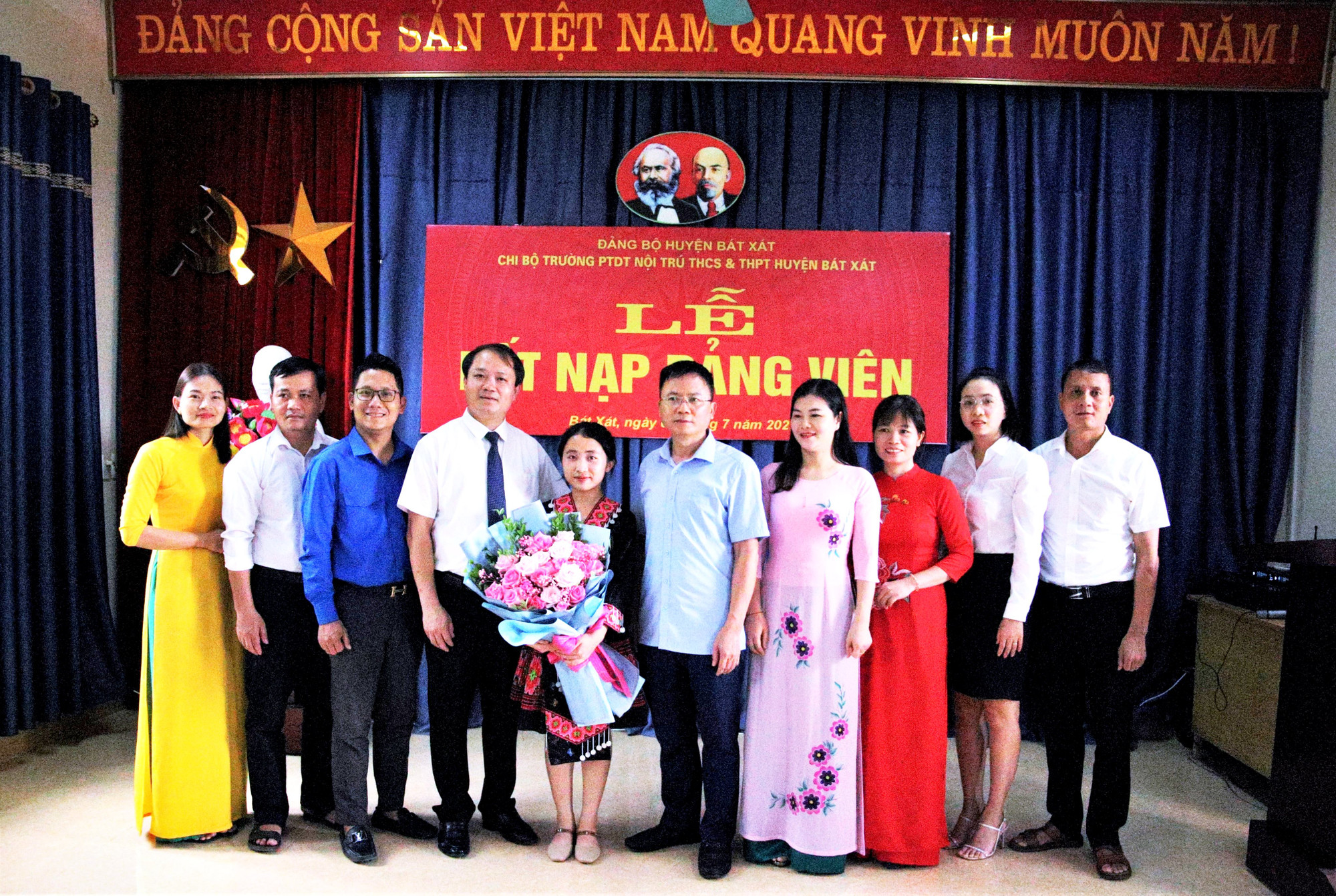 Lãnh đạo Huyện ủy Bát Xát và Trường Phổ thông Dân tộc nội trú THCS và THPT Bát Xát (Lào Cai) tặng hoa chúc mừng đảng viên Vừ Thị Sấy, học sinh lớp 12A của nhà trường. (Ảnh: Quốc Hồng)