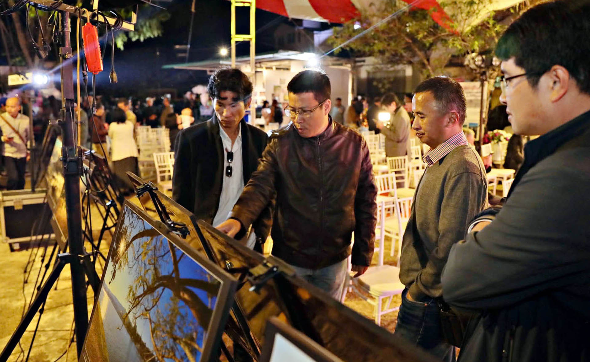 Nhiếp ảnh gia Trương Ngọc Thụy (thứ 2, bên phải) cùng những người thưởng lãm tại Triển lãm ảnh nghệ thuật - chuyên đề "Những sắc màu thành phố ngàn hoa".