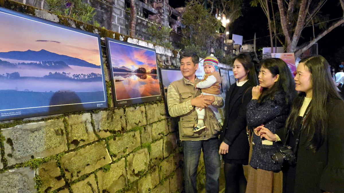 Người dân Đà Lạt cùng tác giả Võ Trang bên những tác phẩm của anh tại Triển lãm ảnh nghệ thuật - chuyên đề “Những sắc màu thành phố ngàn hoa”.