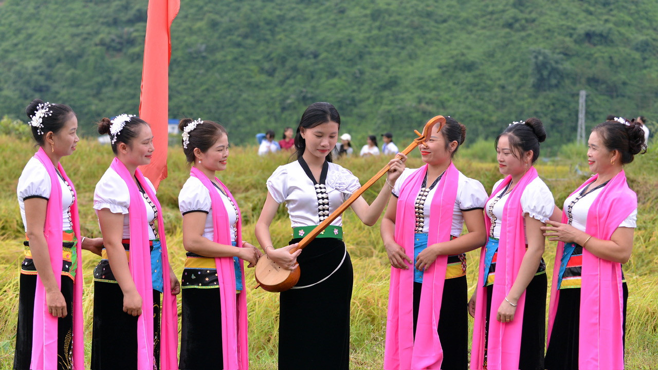 Các thiếu nữ Thái thể hiện khả năng chơi đàn tính tẩu tại lễ hội.
