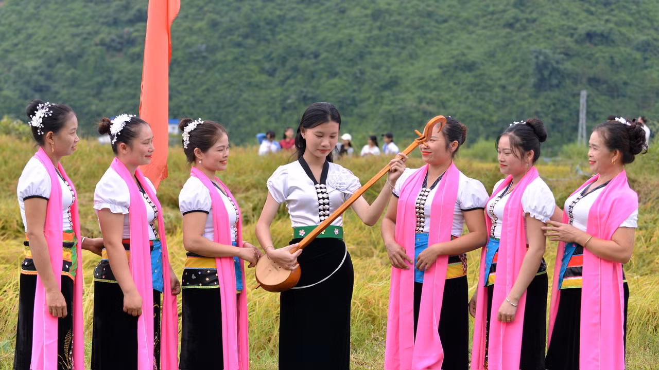 Các thiếu nữ Thái thể hiện khả năng chơi đàn tính tẩu tại lễ hội.