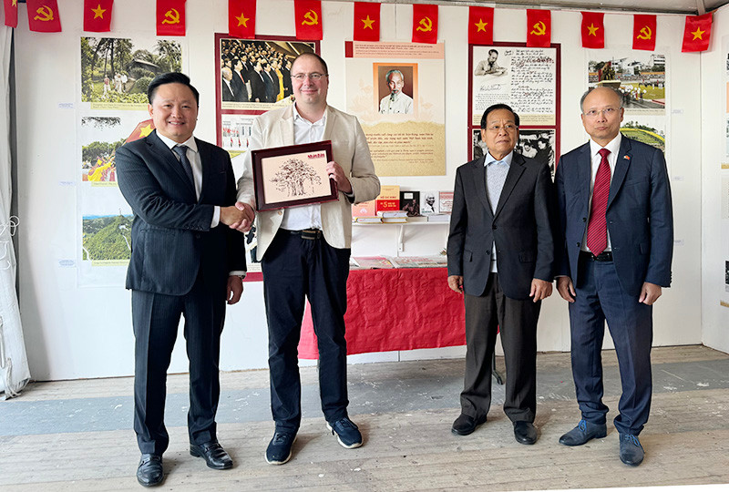 Phó Tổng Biên tập Phan Văn Hùng tặng quà lưu niệm cho Trưởng Ban Đối ngoại Trung ương Đảng Cộng sản Pháp Vincent Boulet. (Ảnh: MINH DUY)