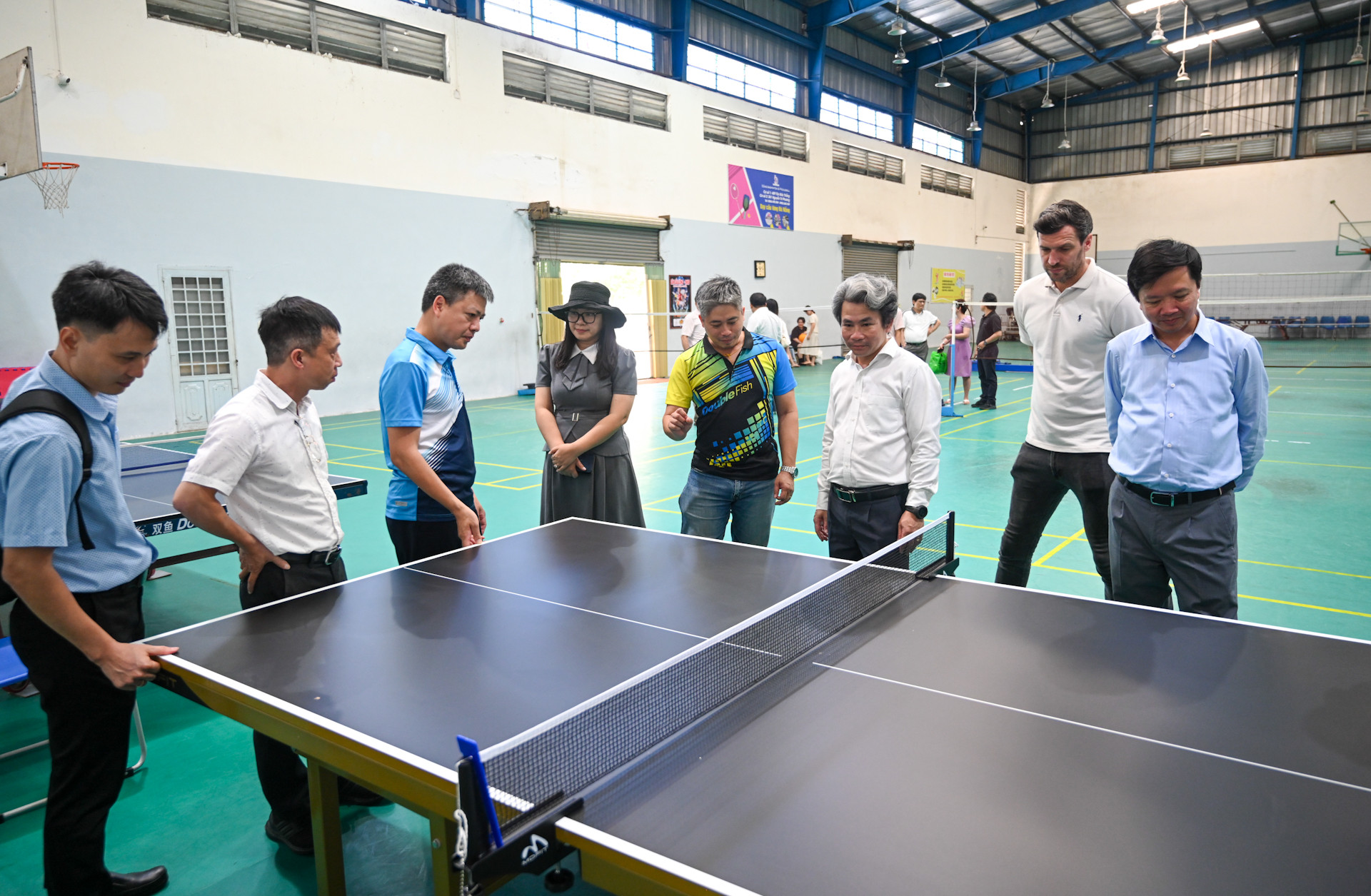 Các đại biểu nghe giới thiệu về bàn bóng bàn tiêu chuẩn quốc tế trao tặng cho trường.