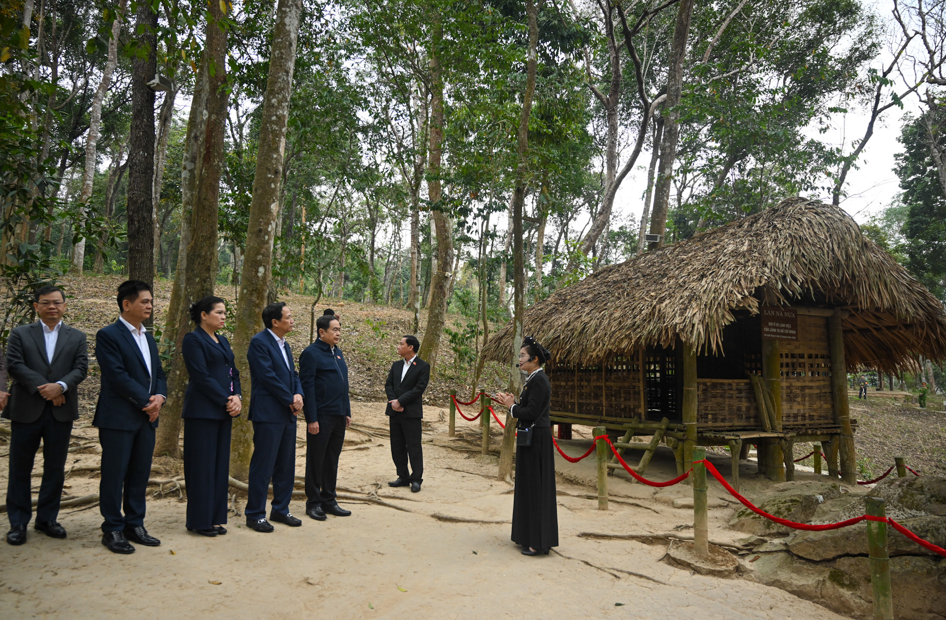 Chủ tịch Quốc hội Trần Thanh Mẫn và các đại biểu nghe giới thiệu về di tích lán Nà Nưa.