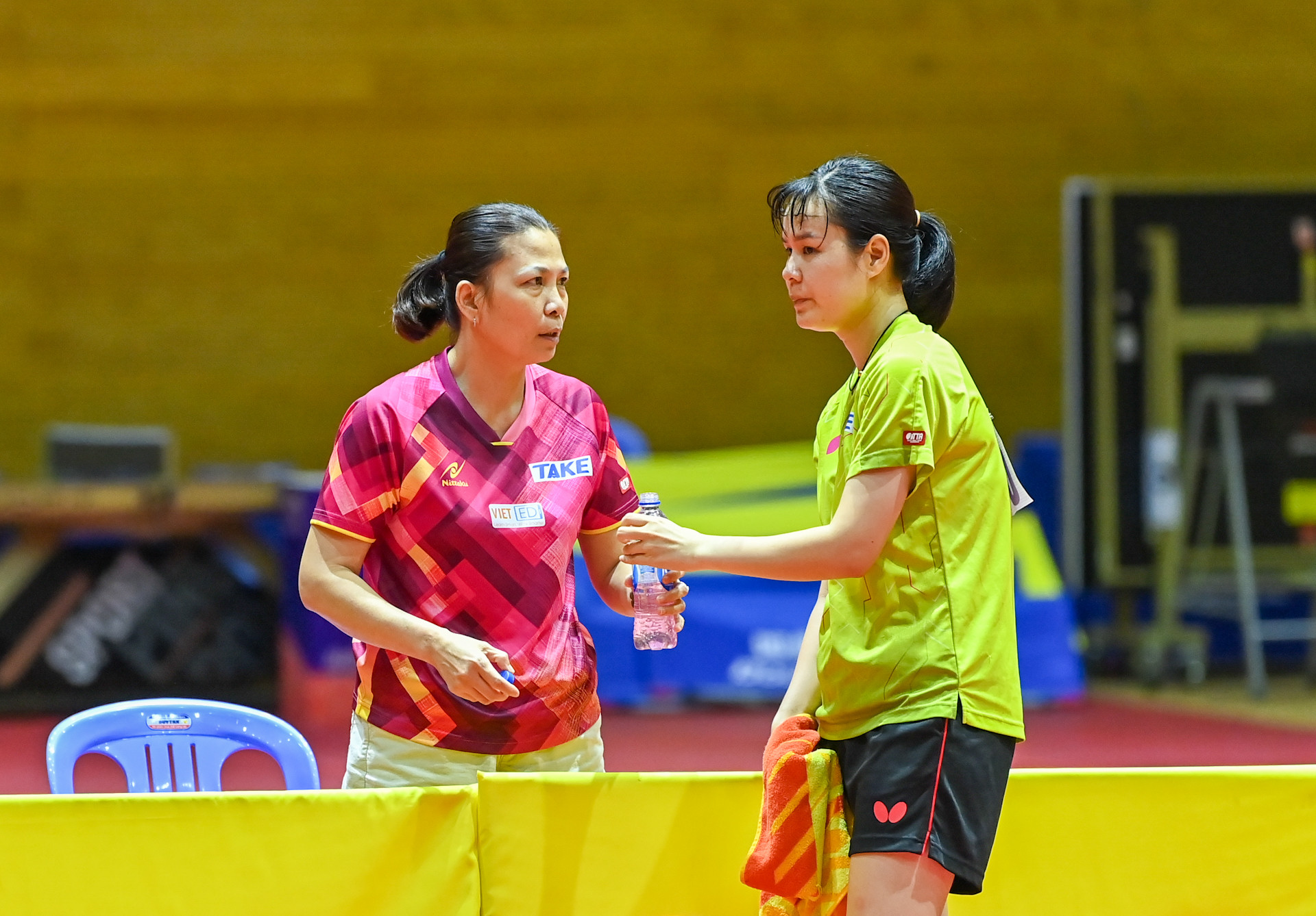 Bên kia sân thi đấu, tay vợt Nguyễn Thị Nga lắng nghe chỉ đạo của huấn luyện viên.