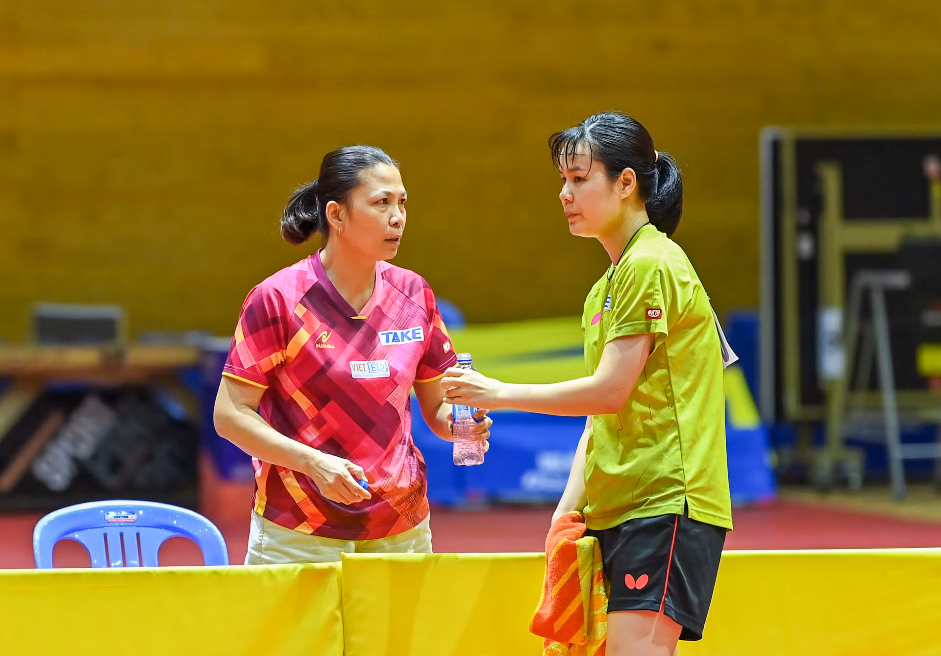 Bên kia sân thi đấu, tay vợt Nguyễn Thị Nga lắng nghe chỉ đạo của huấn luyện viên.