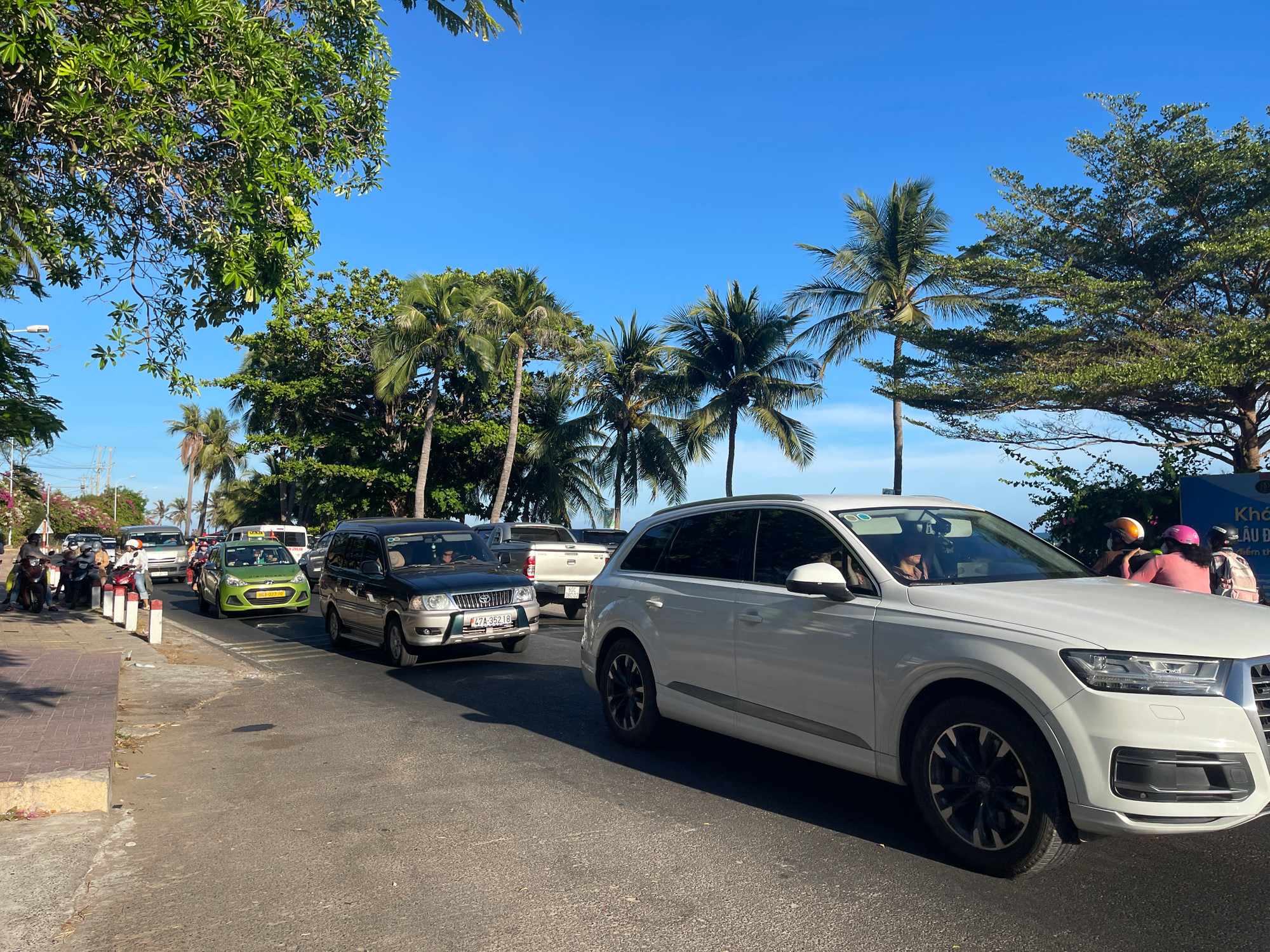 Nhiều ô-tô từ các tỉnh, thành phố khác dừng tại khu vực bãi tắm Đá Ông Địa