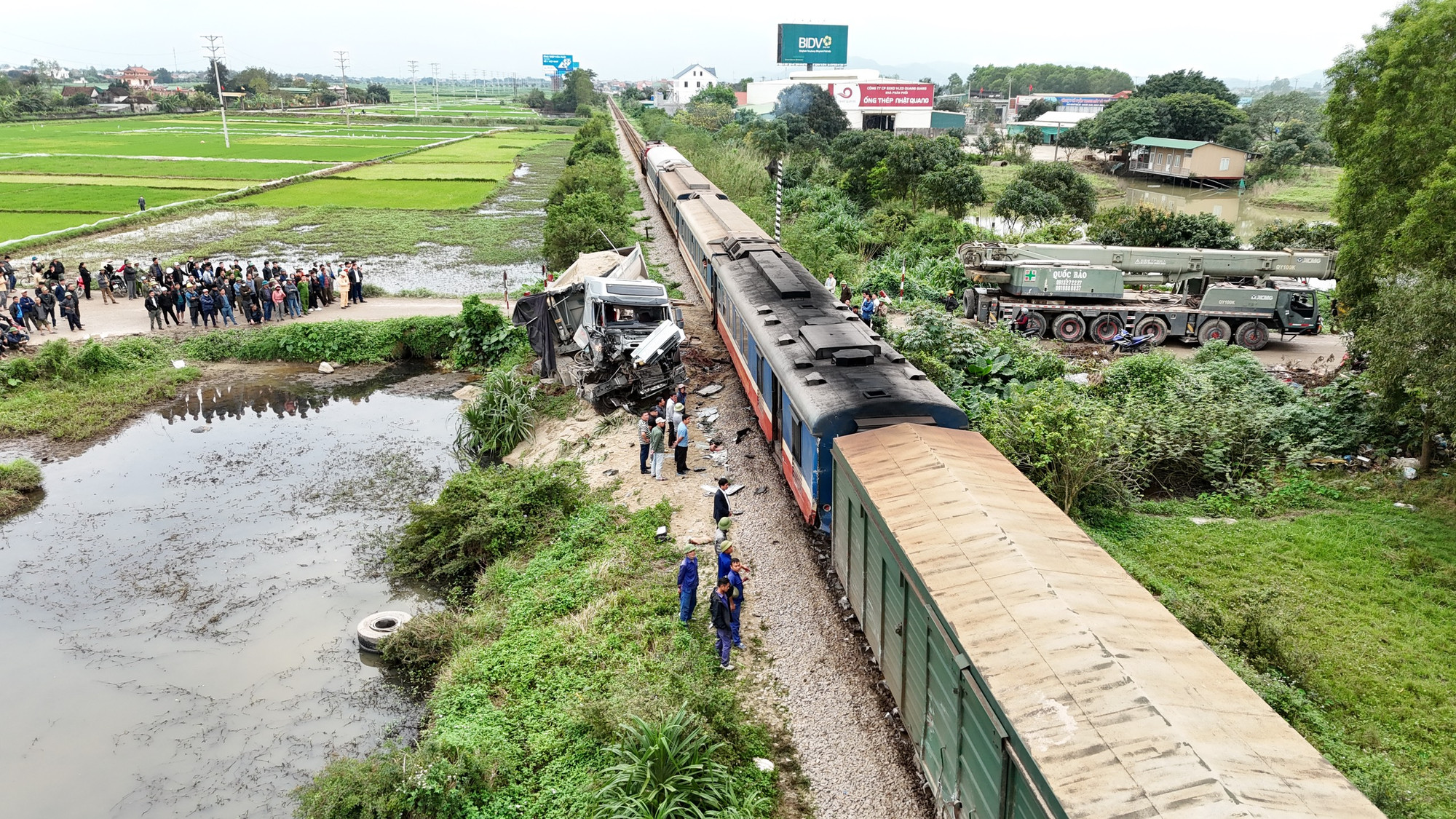 Xe tải bị đâm nát phần cabin và lật nghiêng bên đường.