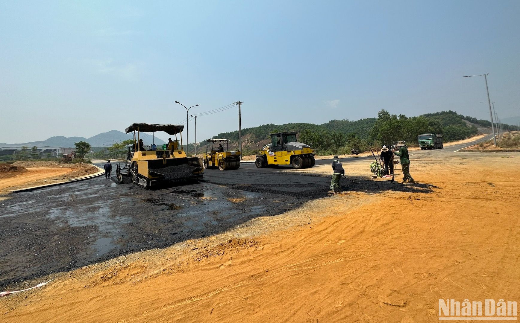 Máy móc phương tiện cùng các công nhân đội nắng hơn 40 độ để thảm nhựa mặt đường đoạn cuối tuyến.
