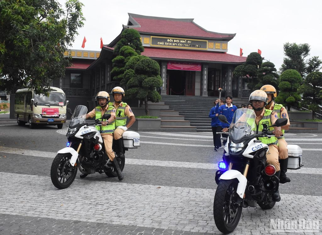 Ngọn đuốc được vận động viên rước đi, khởi hành từ Bảo tàng Hồ Chí Minh, Chi nhánh Quân Khu 5. (Ảnh ANH ĐÀO)