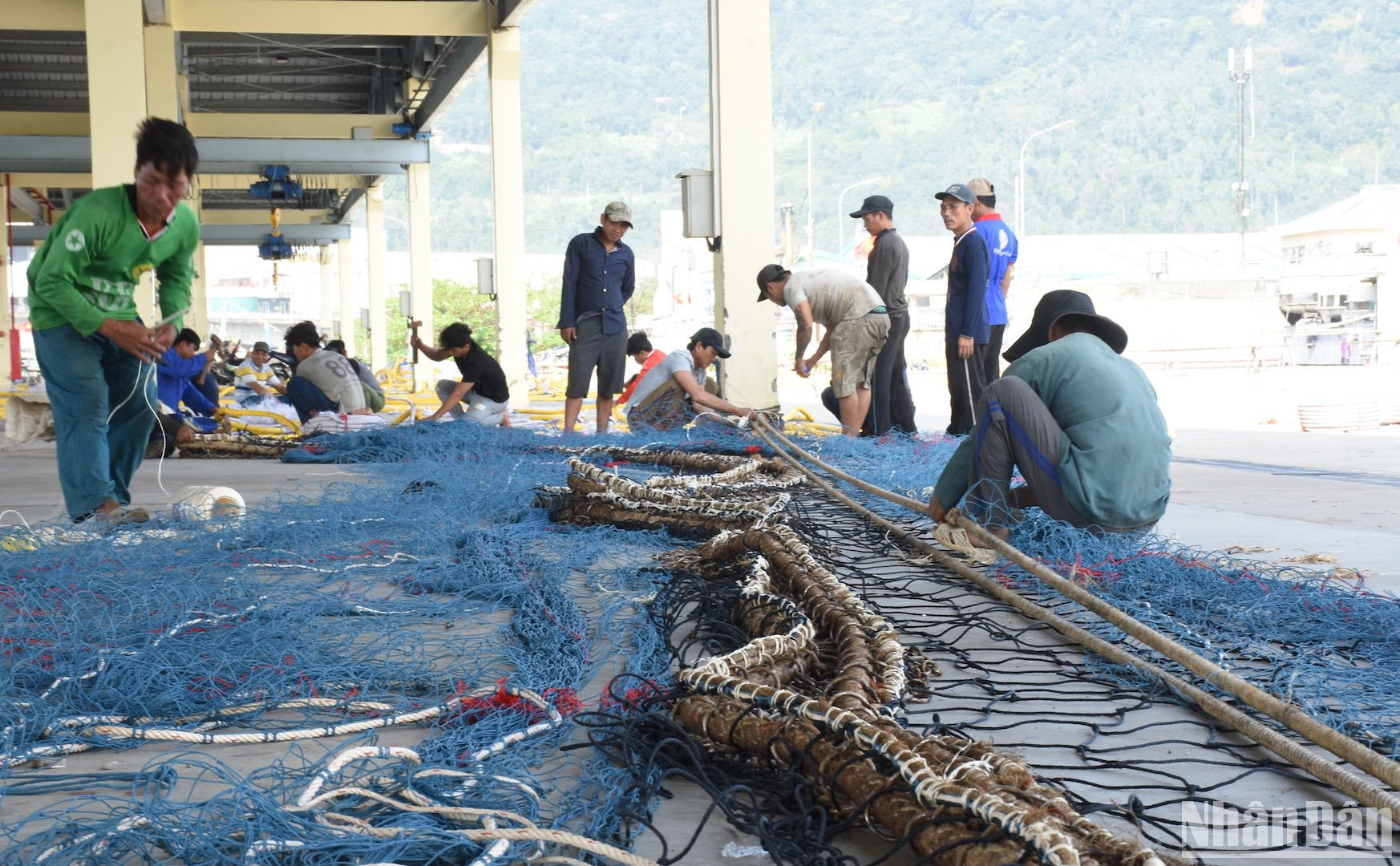Hàng chục ngư dân đang tập trung vá lưới, chuẩn bị cho chuyến biển đầu năm.
