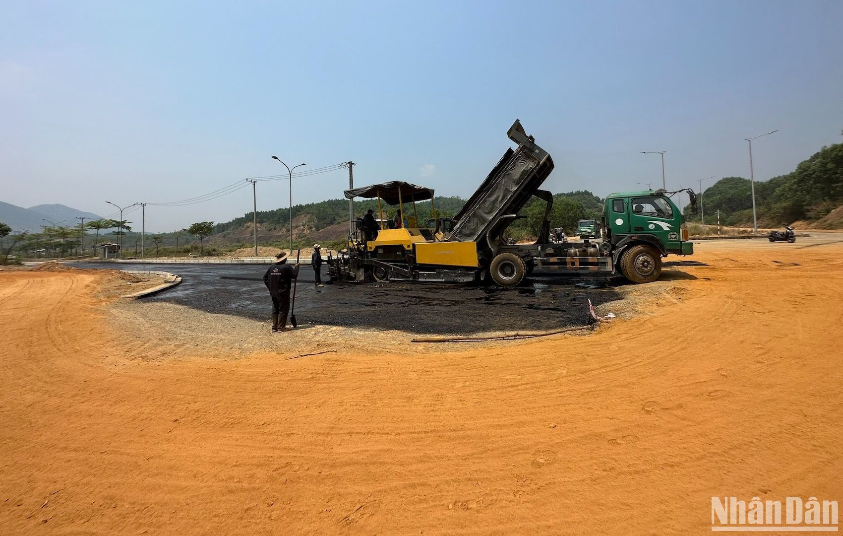 Các công nhân này cho hay, công việc gấp rút theo tiến độ và anh em tăng ca, làm giữa nắng nóng nhiều ngày qua. Trong ảnh là công nhân đang thảm nhựa một đoạn giao với đường nội bộ của Khu công nghệ thông tin tập trung Đà Nẵng