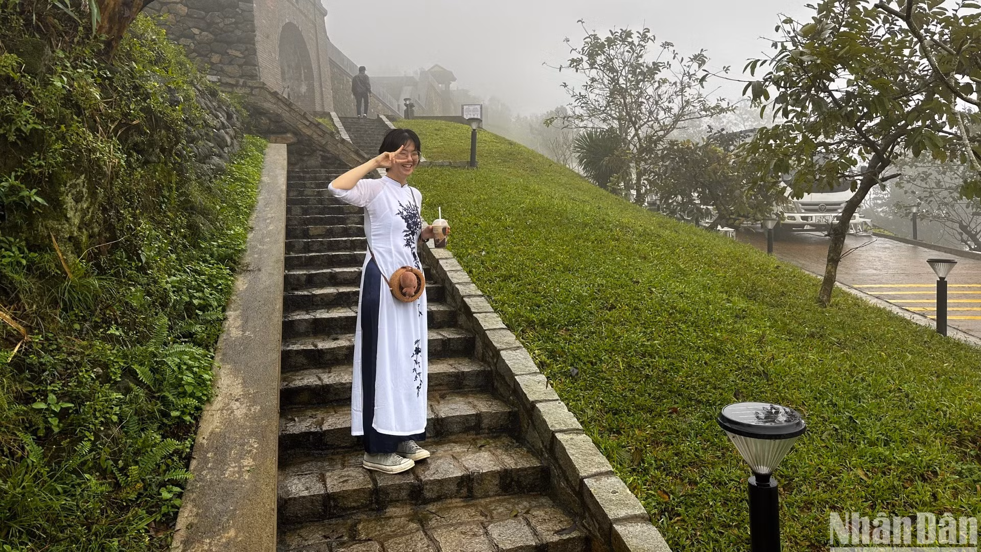 Một du khách người Hàn Quốc mang áo dài Việt Nam Check-in tại Di tích Quốc gia Hải Vân quan sáng 17/12, dù thời tiết mưa và rất lạnh. (Ảnh: ANH ĐÀO)