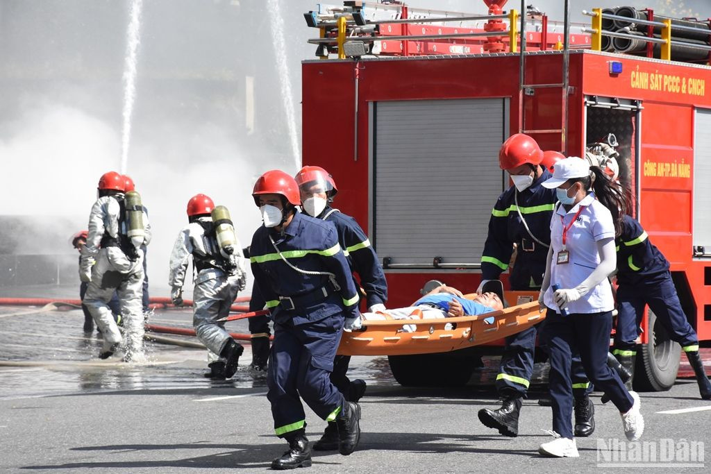 Tài xế xe ô-tô 4 chỗ được lực lượng chức năng giải cứu khỏi cabin và nhanh chóng đưa ra khỏi hiện trường. (Ảnh: ANH ĐÀO)