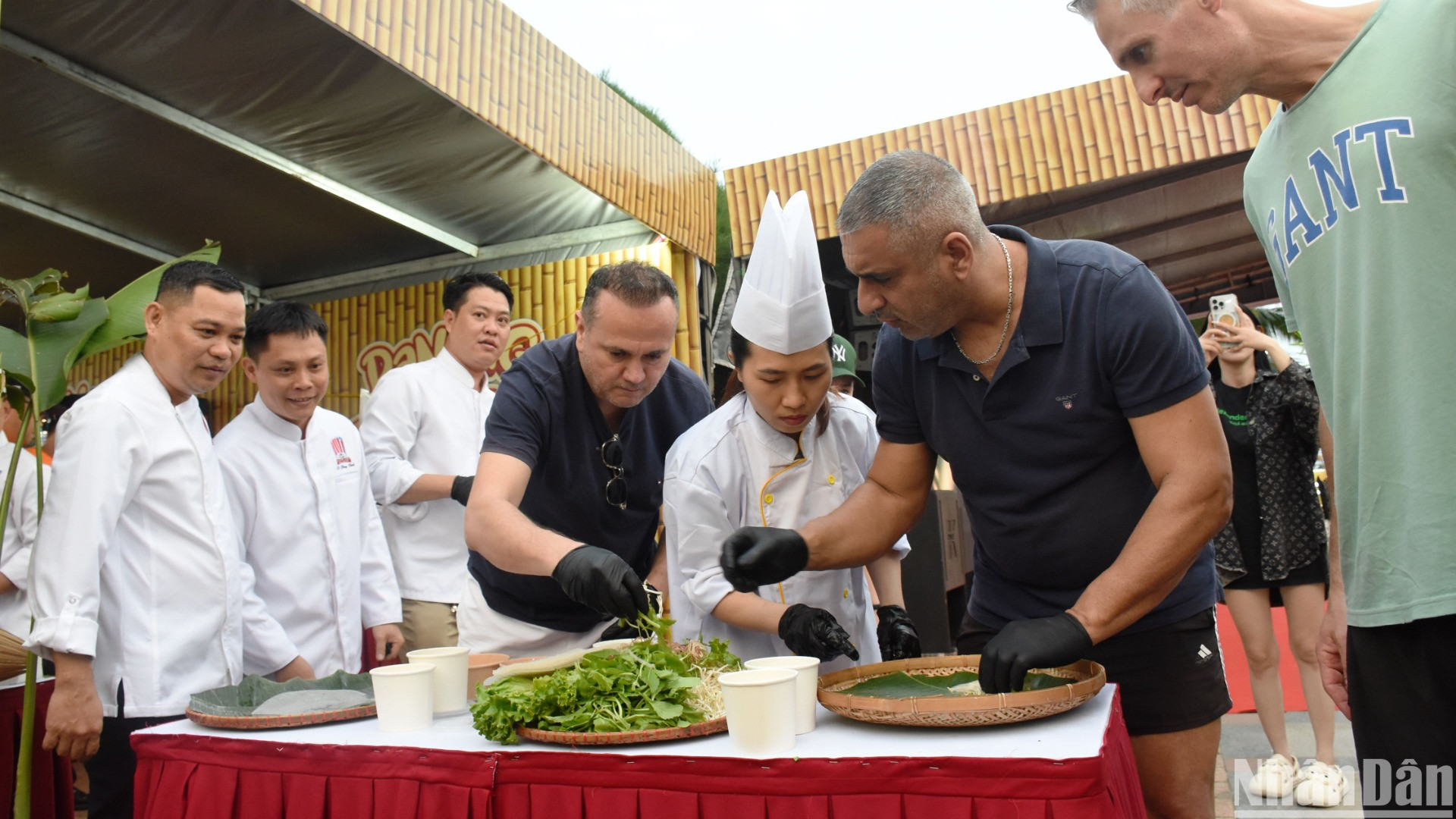 Du khách quốc tế trải nghiệm cuốn gỏi tại Lễ hội. (Ảnh: ANH ĐÀO)