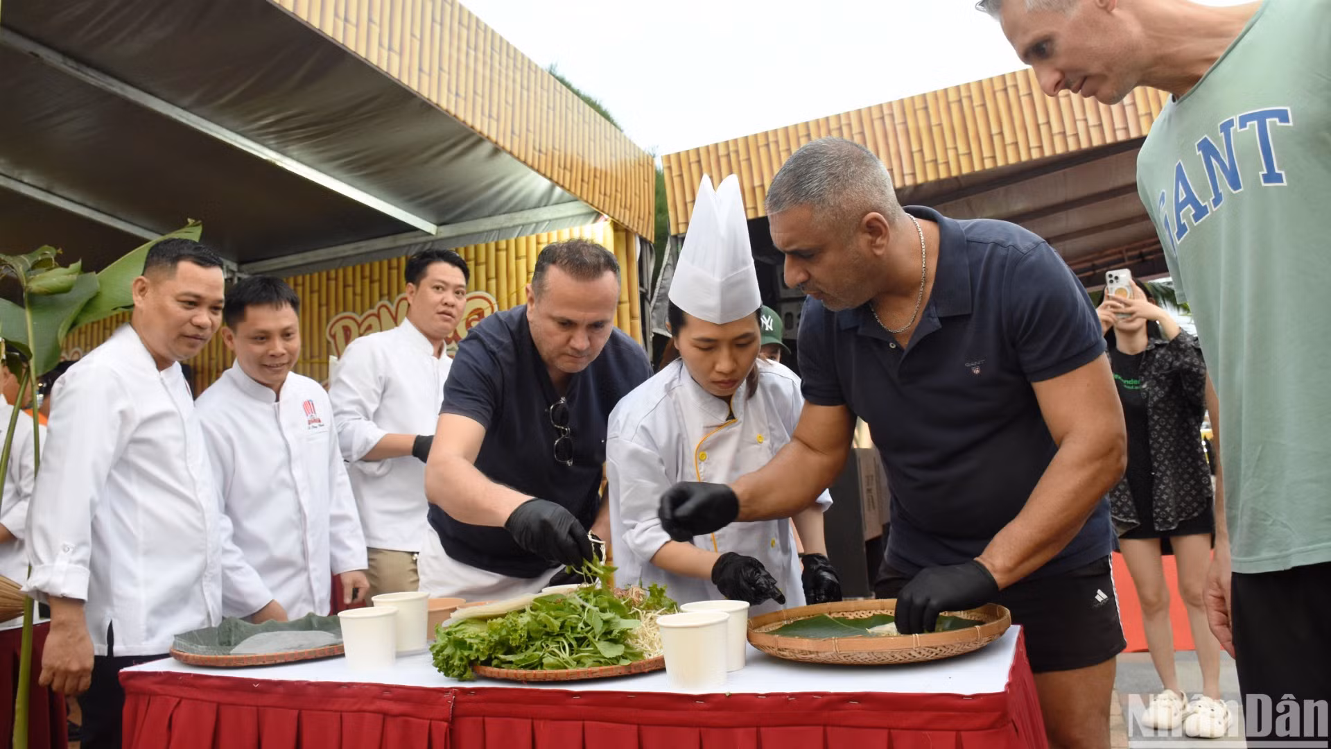 Du khách quốc tế trải nghiệm cuốn gỏi tại Lễ hội. (Ảnh: ANH ĐÀO)