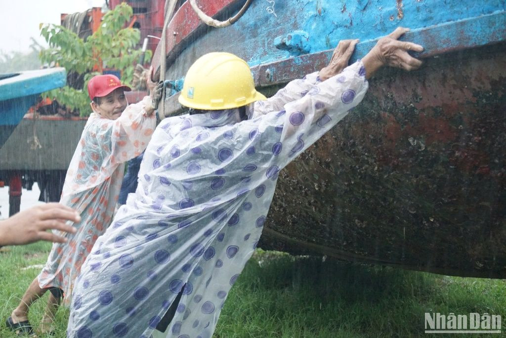 Cùng nhau đưa tàu thuyền lên bờ. (Ảnh: ANH ĐÀO)