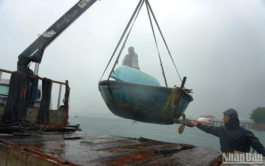 Thuyền thúng được vận chuyển lên xe tải để chở về nơi tập kết an toàn. (Ảnh: ANH ĐÀO)