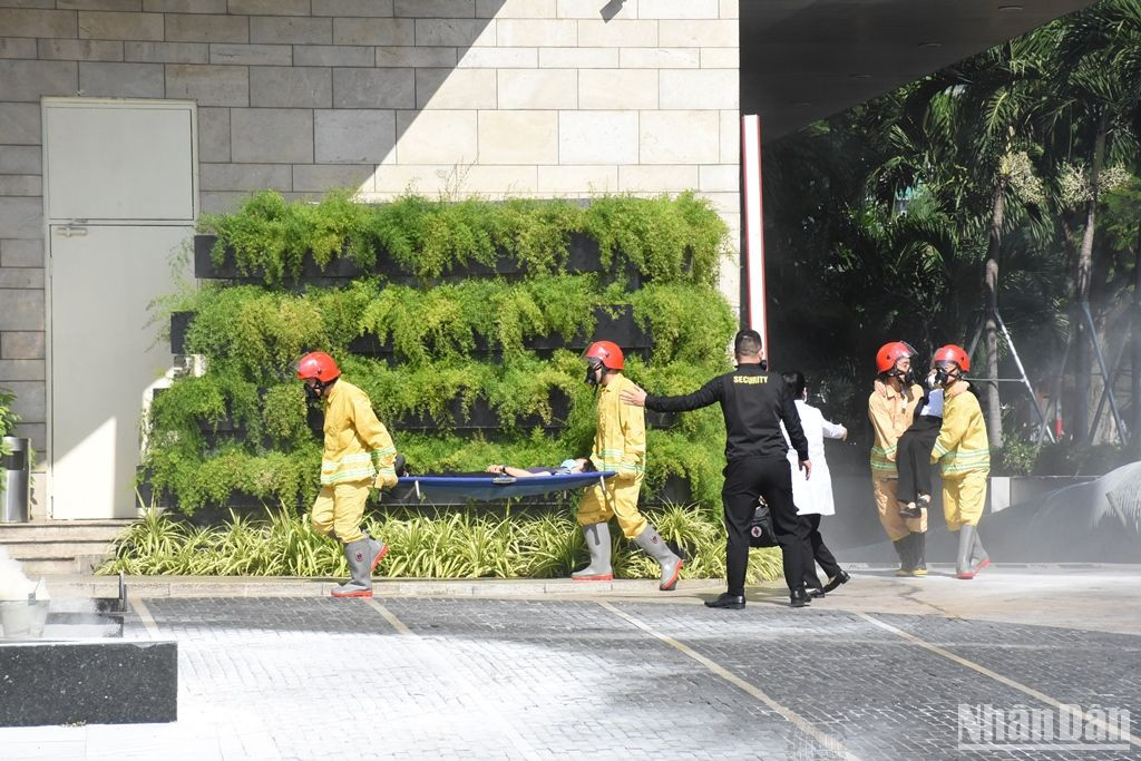 Nhanh chóng đưa các nạn nhân bị ngạt khí ra ngoài... (Ảnh: ANH ĐÀO)