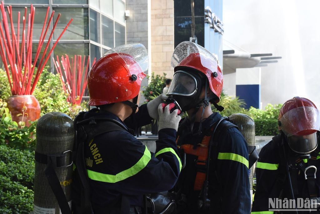 Lực lượng phòng cháy chữa cháy, cứu nạn cứu hộ sử dụng mặt nạ chống độc để tiếp cận đưa các nạn nhân bị ngạt khí ra bên ngoài. (Ảnh: ANH ĐÀO)