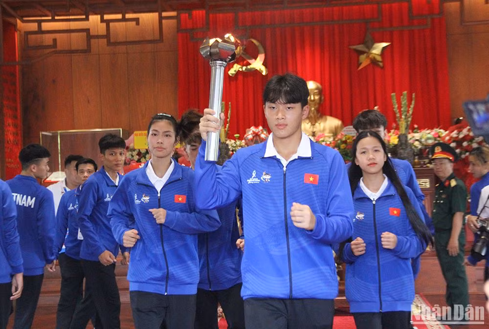 Vận động viên Mai Cao Khải, vận động viên Bơi của Đoàn Thể thao Việt Nam là người thực hiện nghi lễ nhận lửa, rước đuốc về Cung thể thao Tiên Sơn chuẩn bị cho đêm khai mạc tối nay (1/6). (Ảnh ANH ĐÀO)
