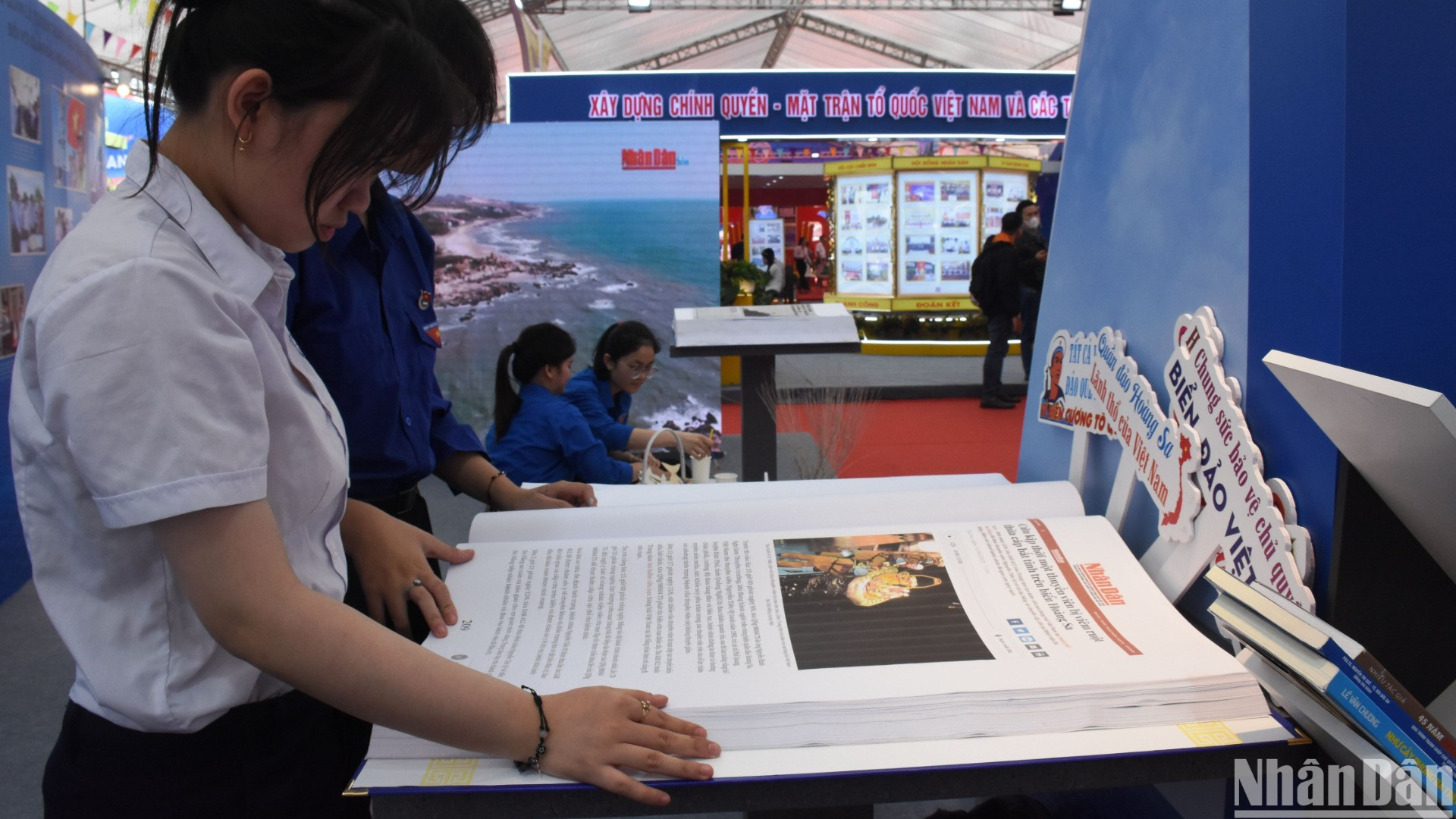 Các em học sinh Đà Nẵng đọc Báo Nhân Dân tại không gian triển lãm về chủ quyền biển đảo, giới thiệu hình ảnh về các hoạt động của quần đảo Hoàng Sa. (Ảnh: ANH ĐÀO)