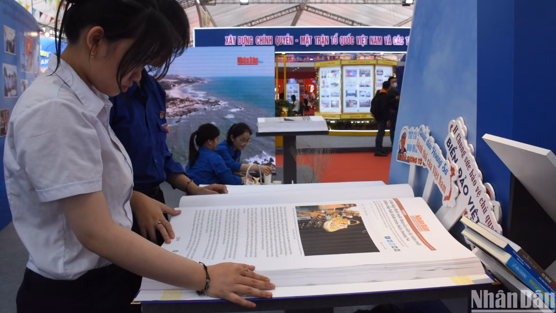 Các em học sinh Đà Nẵng đọc Báo Nhân Dân tại không gian triển lãm về chủ quyền biển đảo, giới thiệu hình ảnh về các hoạt động của quần đảo Hoàng Sa. (Ảnh: ANH ĐÀO)