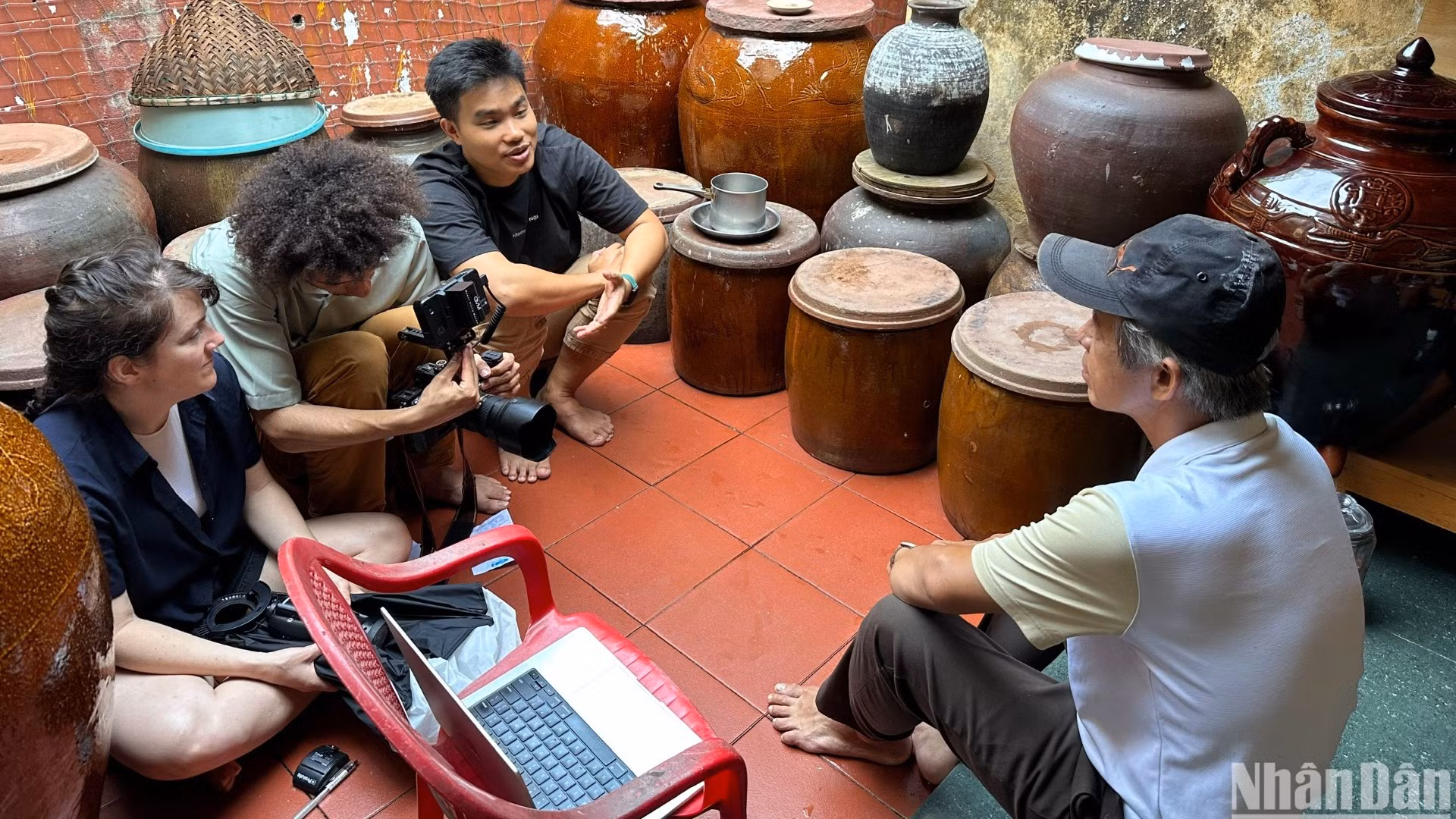 Ông Huỳnh Văn Mười (59 tuổi, trú phường Mân Thái, quận Sơn Trà, Đà Nẵng) đang giới thiệu về văn hóa biển và nghề làm nước mắm nhĩ của ngư dân làng biển Mân Thái với du khách nước ngoài. (Ảnh: ANH ĐÀO)