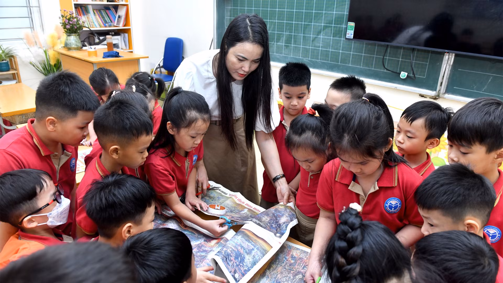 Cô giáo Nguyễn Thu Hòa hướng dẫn các cháu học sinh cắt dán bức tranh panorama “Chiến dịch Điện Biên Phủ”.