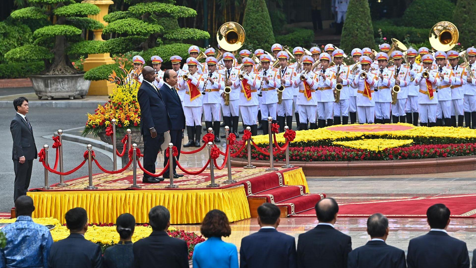 Chủ tịch nước Nguyễn Xuân Phúc và Tổng thống Uganda Yoweri Kaguta Museveni trên bục danh dự, nghe quân nhạc cử Quốc thiều hai nước.