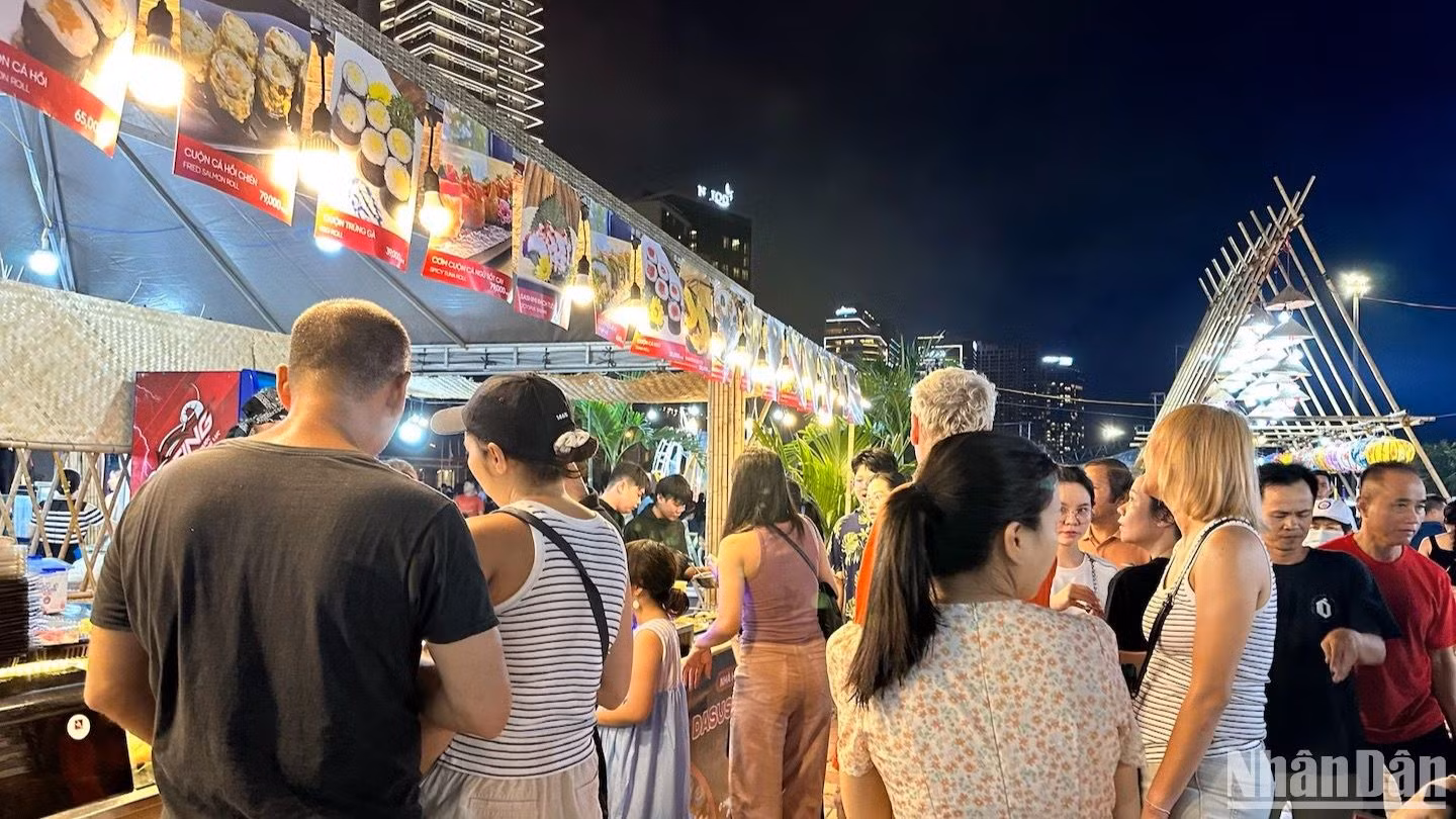 Du khách quốc tế hào hứng trải nghiệm ẩm thực tại Khai mạc Lễ hội Tận hưởng Đà Nẵng 2024. (Ảnh: ANH ĐÀO)