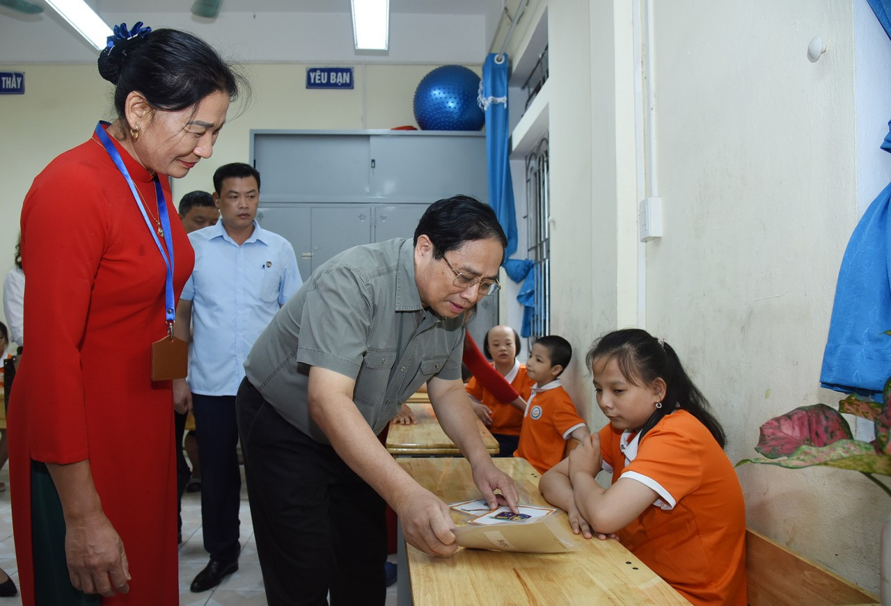 Thủ tướng trò chuyện và cùng các cháu khuyết tật đang học tại Trung tâm tham gia các hoạt động học tập, vui chơi.