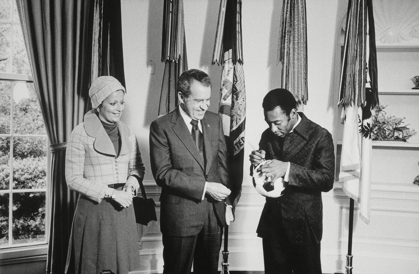 Pelé ký tên lên trái bóng tặng Tổng thống Mỹ Richard Nixon trong lần tới thăm Nhà trắng năm 1973. Trong sự nghiệp của mình, Pelé đã được gặp một số Tổng thống của Xứ cờ hoa. Ông nổi tiếng đến mức Tổng thống Ronald Reagan từng nói năm 1986 rằng: "Pelé, tên tôi là Ronald Reagan. Tôi là Tổng thống Mỹ. Nhưng anh không cần giới thiệu về mình đâu, vì mọi người đều biết Pelé là ai". (Ảnh: Everett/Shutterstock)
