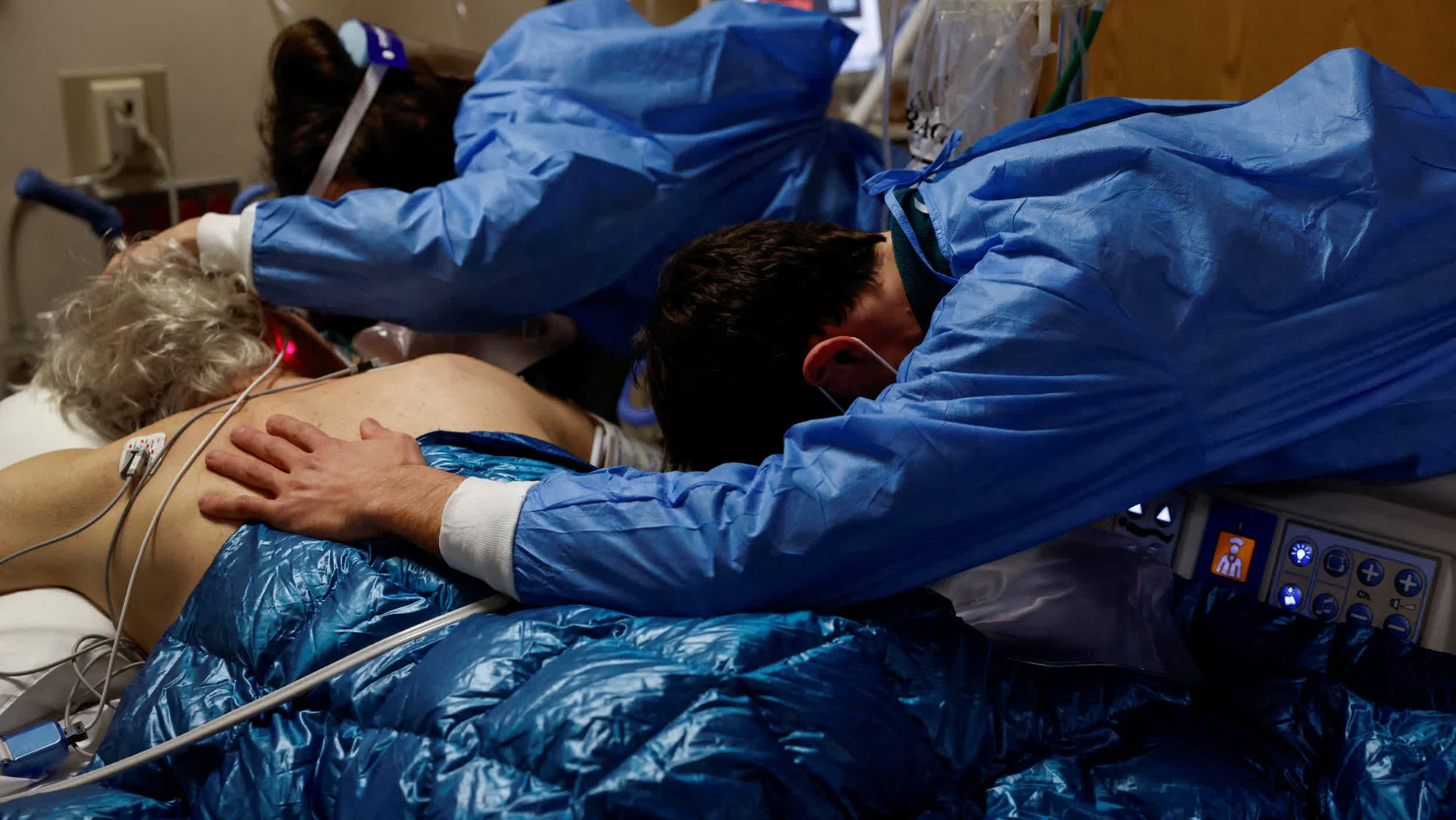 Một bệnh nhân mắc Covid-19 nằm trong vòng tay của các con trước khi ông được đặt nội khí quản tại một bệnh viện ở Mission Viejo, bang California, Mỹ. Trong tháng 1, số ca nhập viện tại Mỹ gia tăng được cho là có liên quan đến biến thể Omicron. (Ảnh: Reuters)