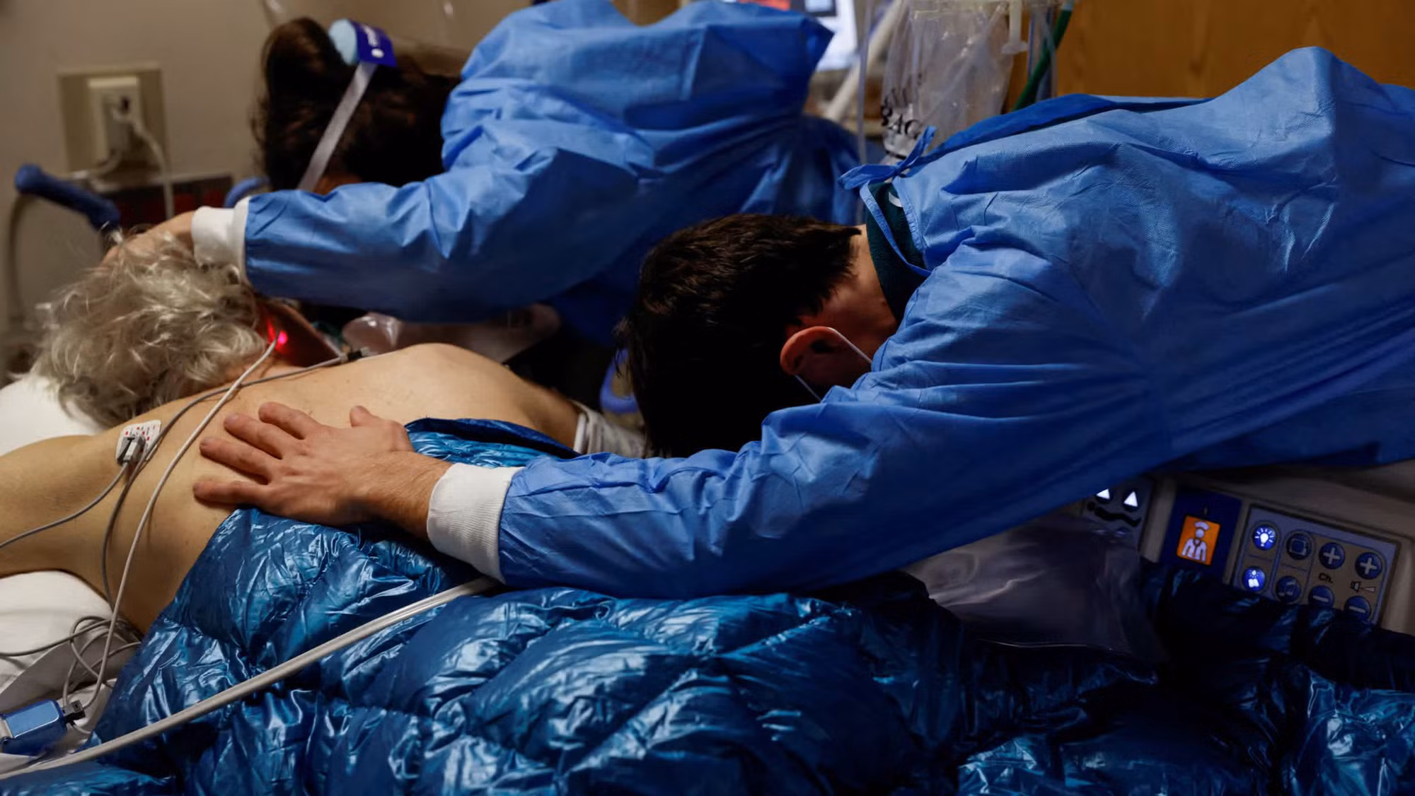 Một bệnh nhân mắc Covid-19 nằm trong vòng tay của các con trước khi ông được đặt nội khí quản tại một bệnh viện ở Mission Viejo, bang California, Mỹ. Trong tháng 1, số ca nhập viện tại Mỹ gia tăng được cho là có liên quan đến biến thể Omicron. (Ảnh: Reuters)