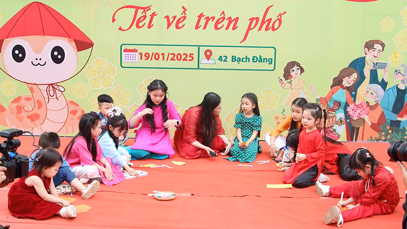 Các em nhỏ viết lời chúc lên hoa mai.