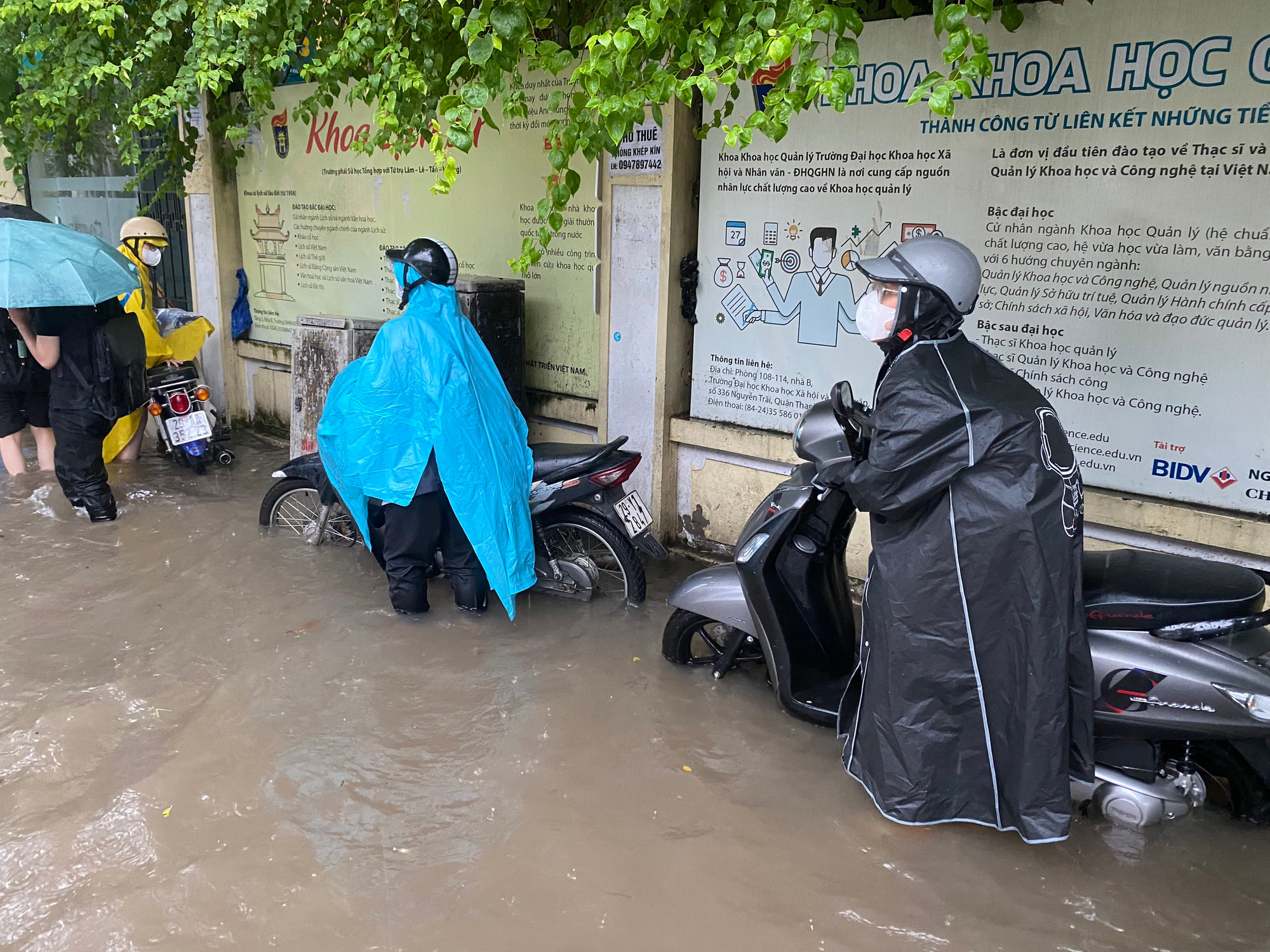 Người tham gia giao thông vất vả vì mưa ngập.