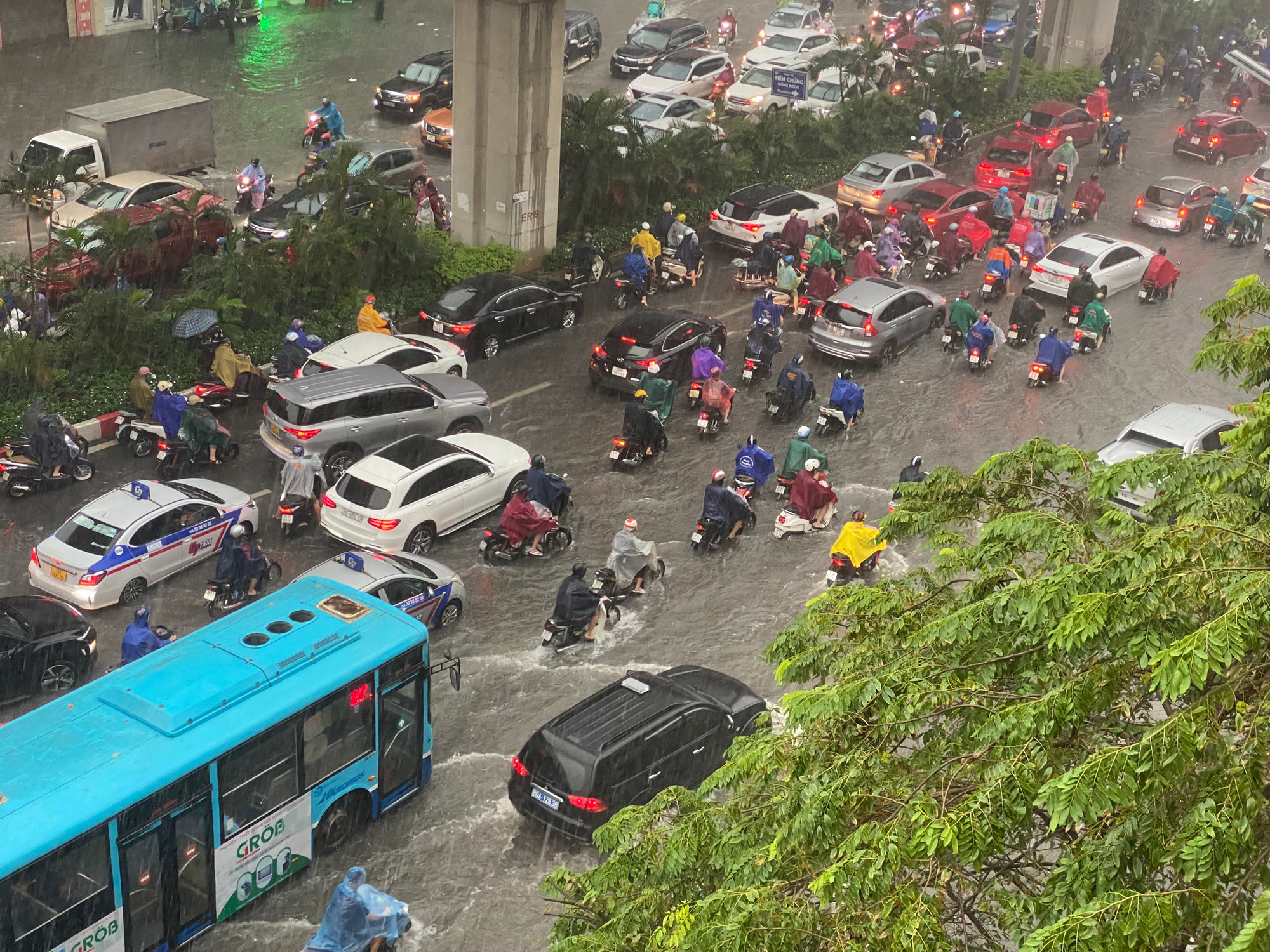 Dòng xe nườm nượp trên đường Nguyễn Trãi. Nước đã ngập quá nửa bánh xe máy do mưa lớn kéo dài.
