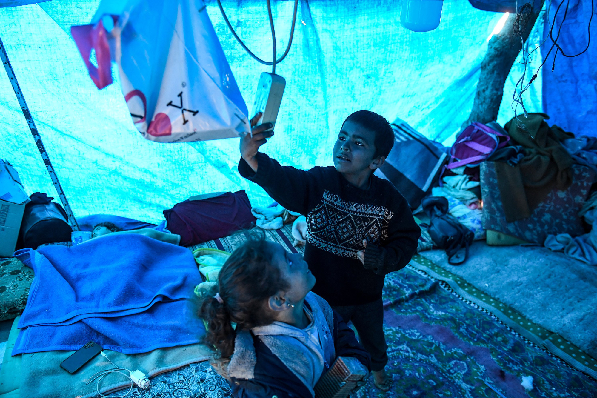 Hai em bé Syria trong "ngôi nhà tạm". Phía bên trái, bé Ayse bị ốm nên được "đặc quyền" ngủ lại bên trong dù trời chưa tối.