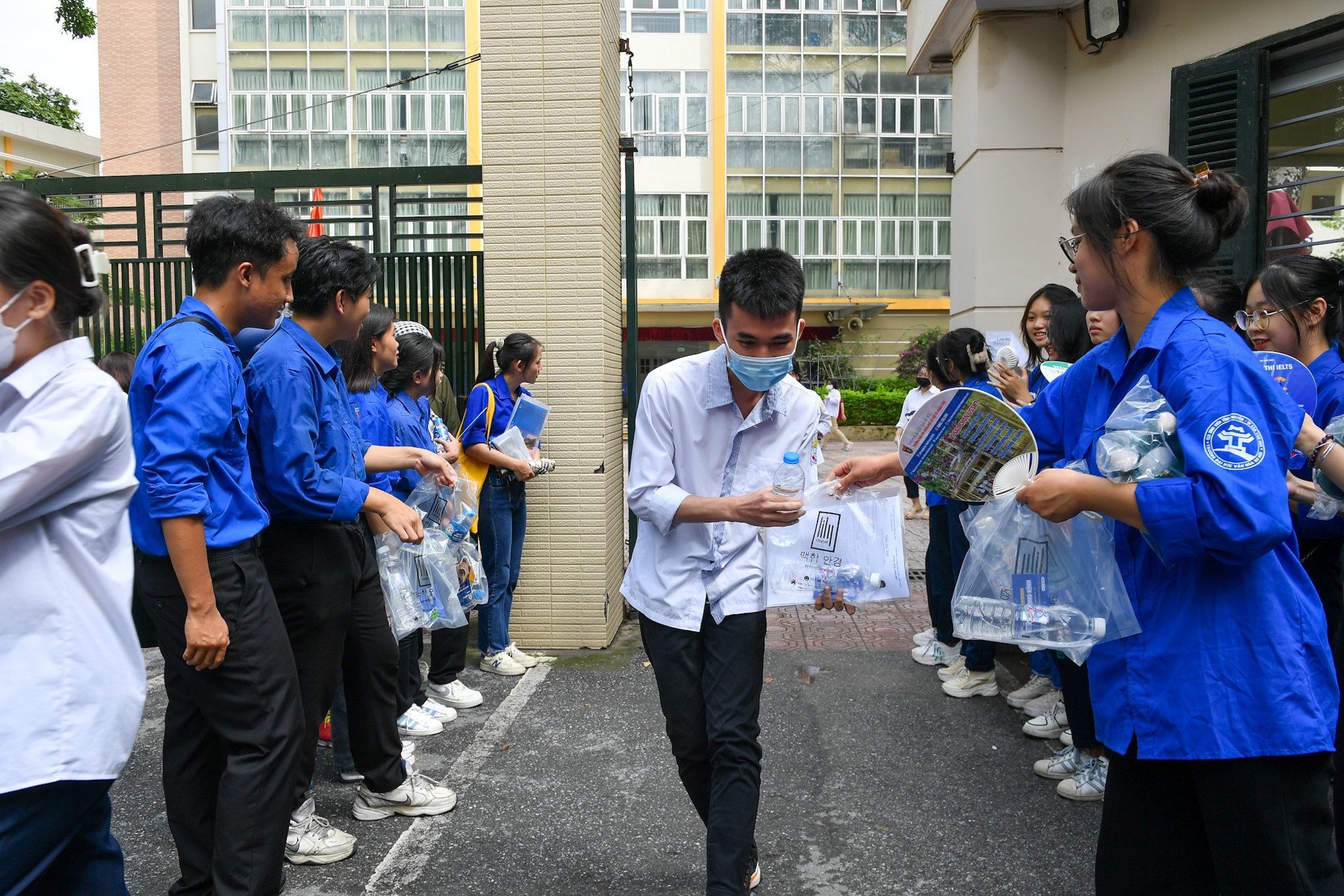 Thí sinh rời điểm thi trường Trung học phổ thông Kim Liên trong tiếng vỗ tay của các tình nguyện viên. (Ảnh: Thành Đạt)