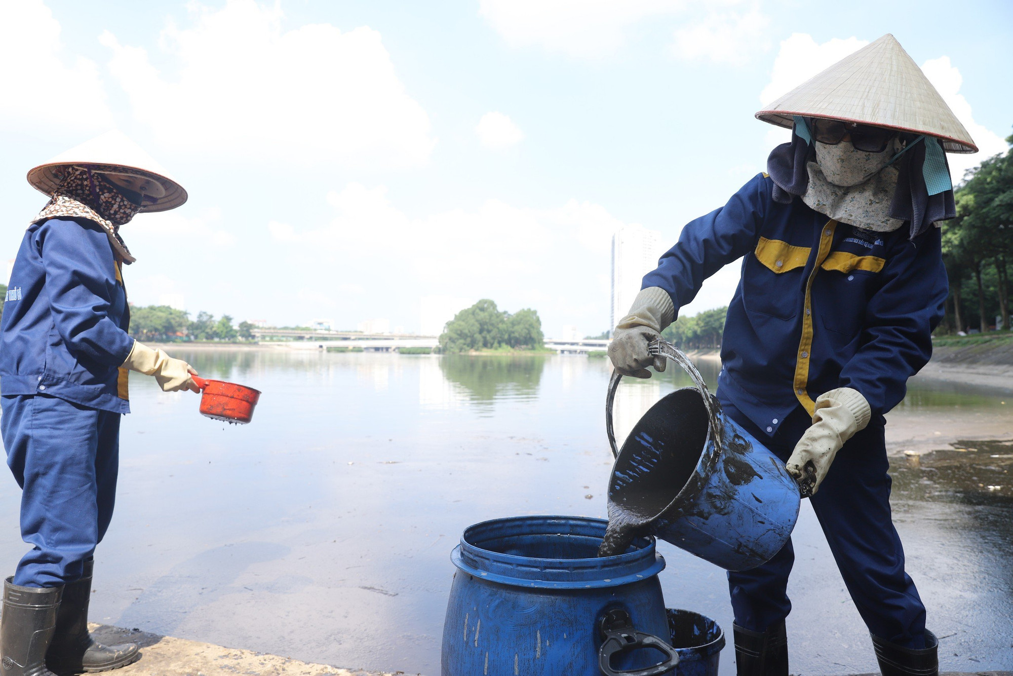 Dầu thải được các công nhân đổ vào các thùng chứa.