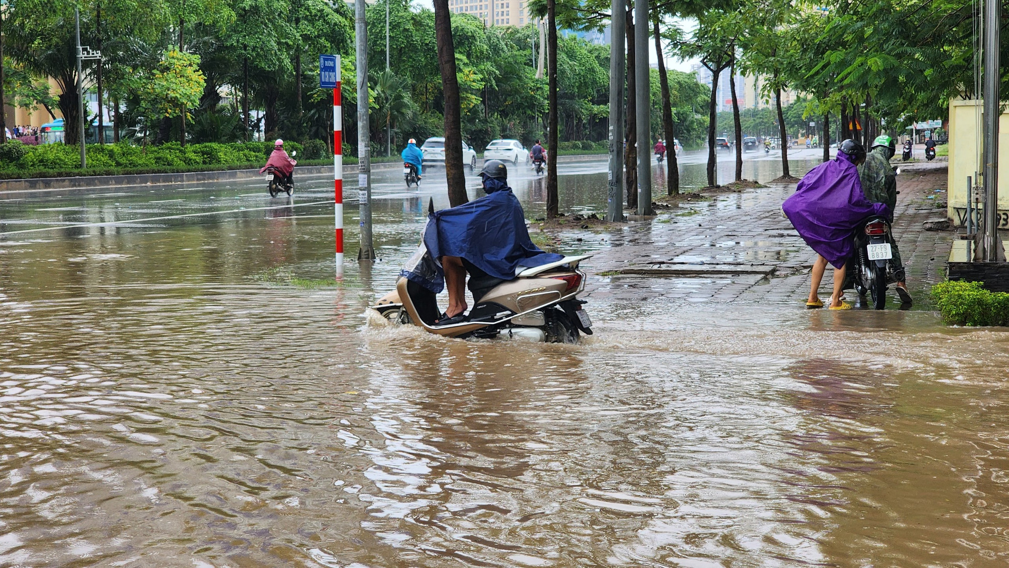 Nước ngập cao khiến việc di chuyển của xe máy gặp nhiều khó khăn.