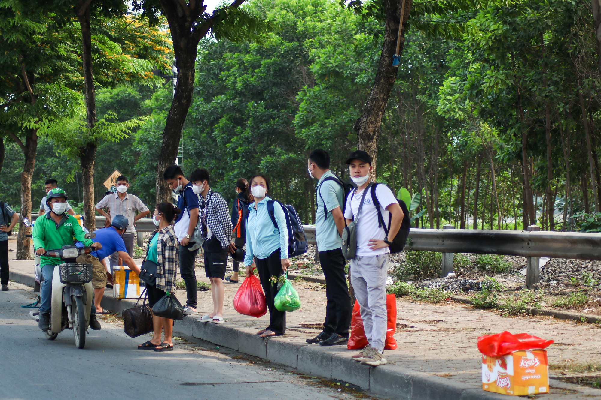 Rất đông người dân đứng ở 2 bên vỉa hè để đón xe khách.