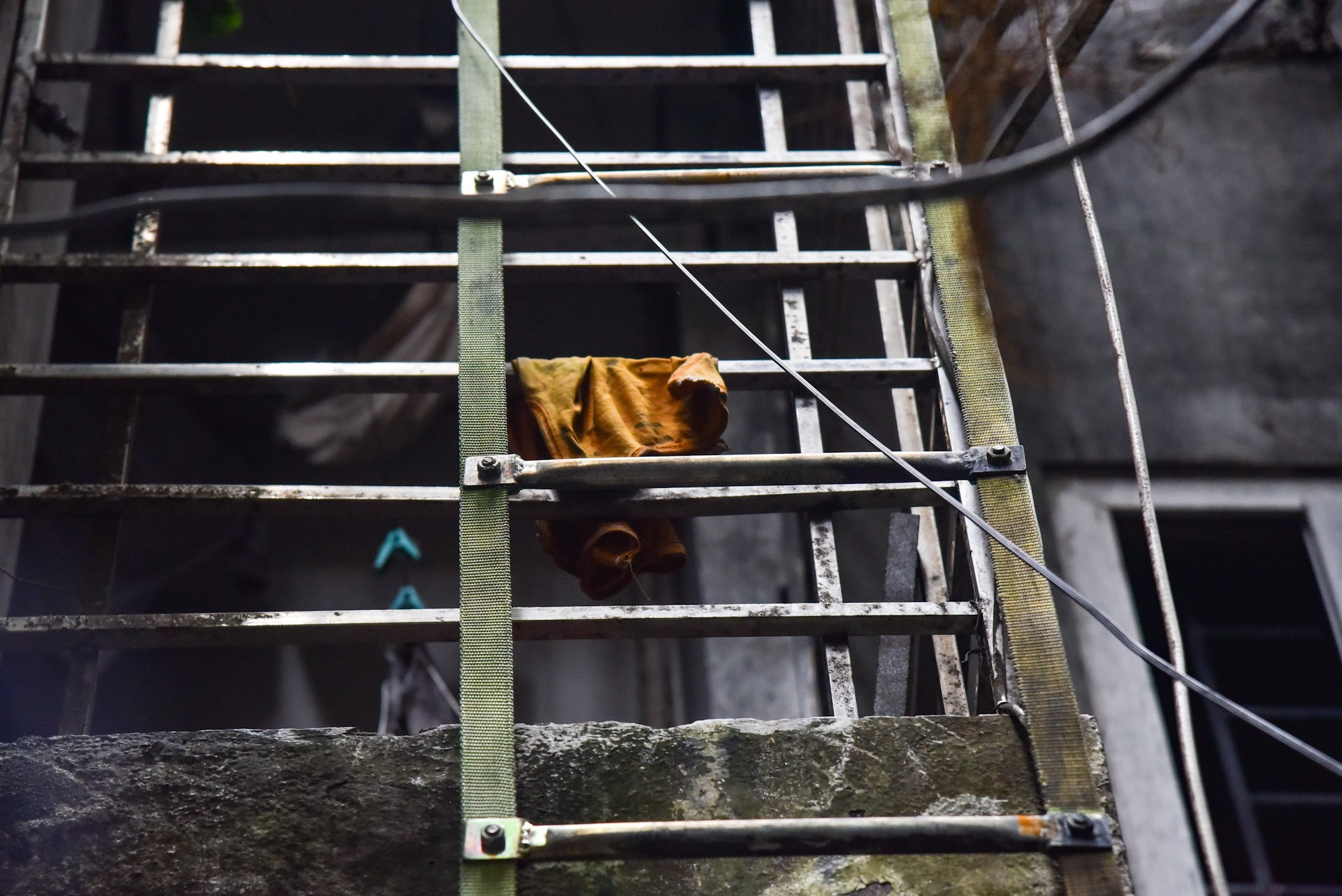 Phía lan can, một mảnh quần áo vương lại. Song cửa cũng bị ám khói đen xì.