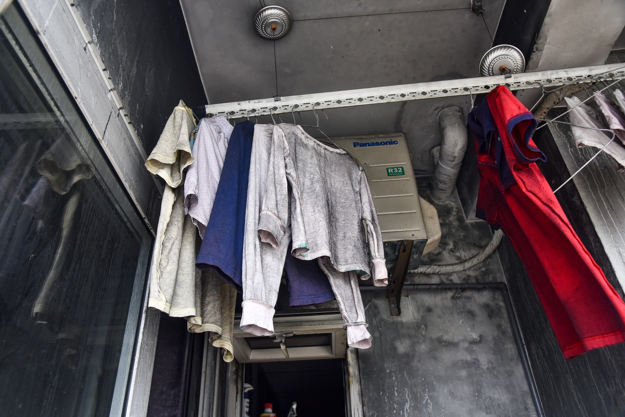 Quần áo treo phía trước lan can một căn hộ vẫn còn ám khói.